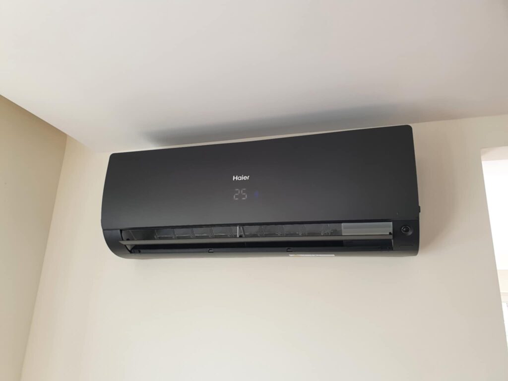REALIZACJE 117 a black air conditioner on a white wall